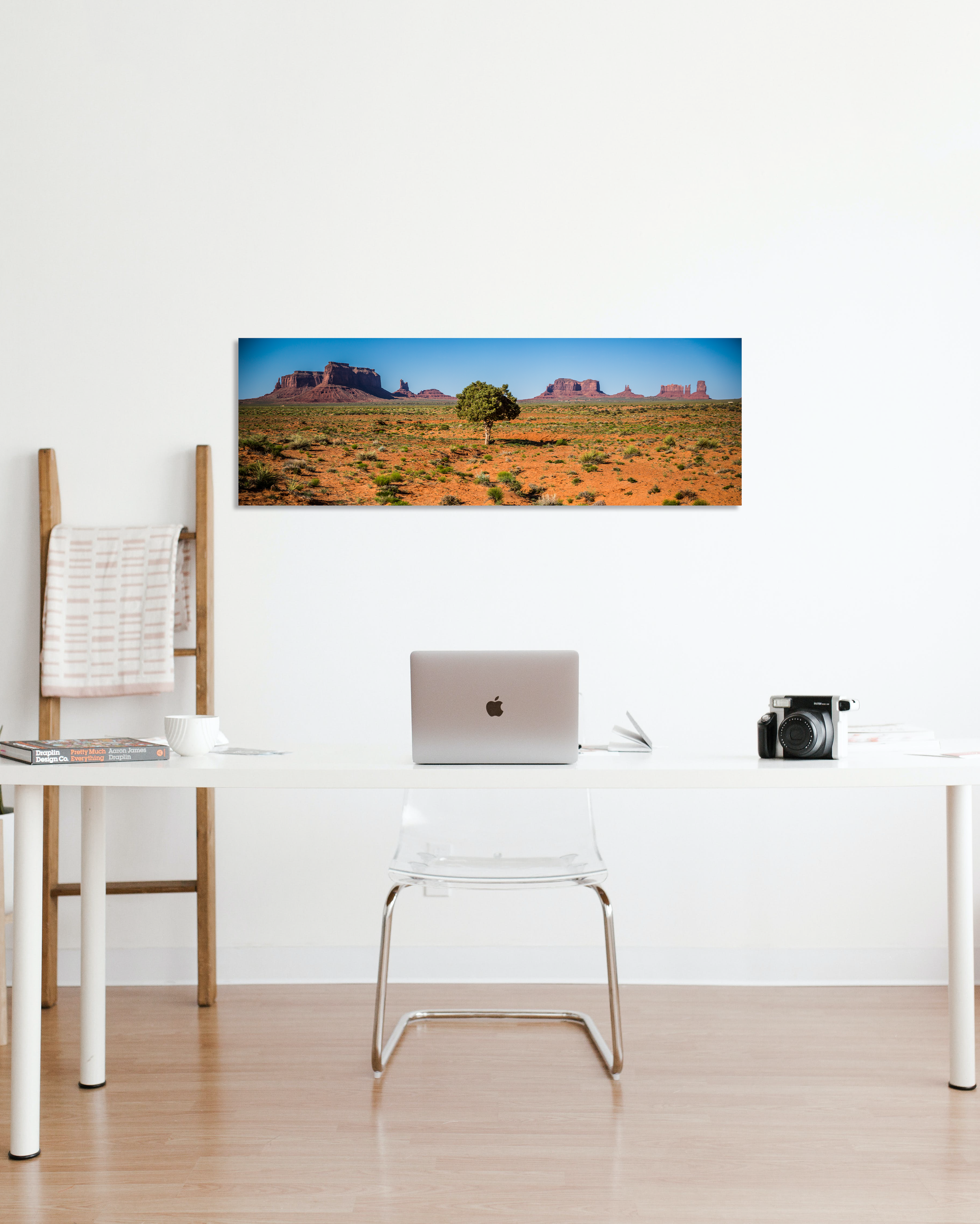 A small office is decorated with a photograph showcasing the arid plateaus and mesas of the American Southwest Desert.