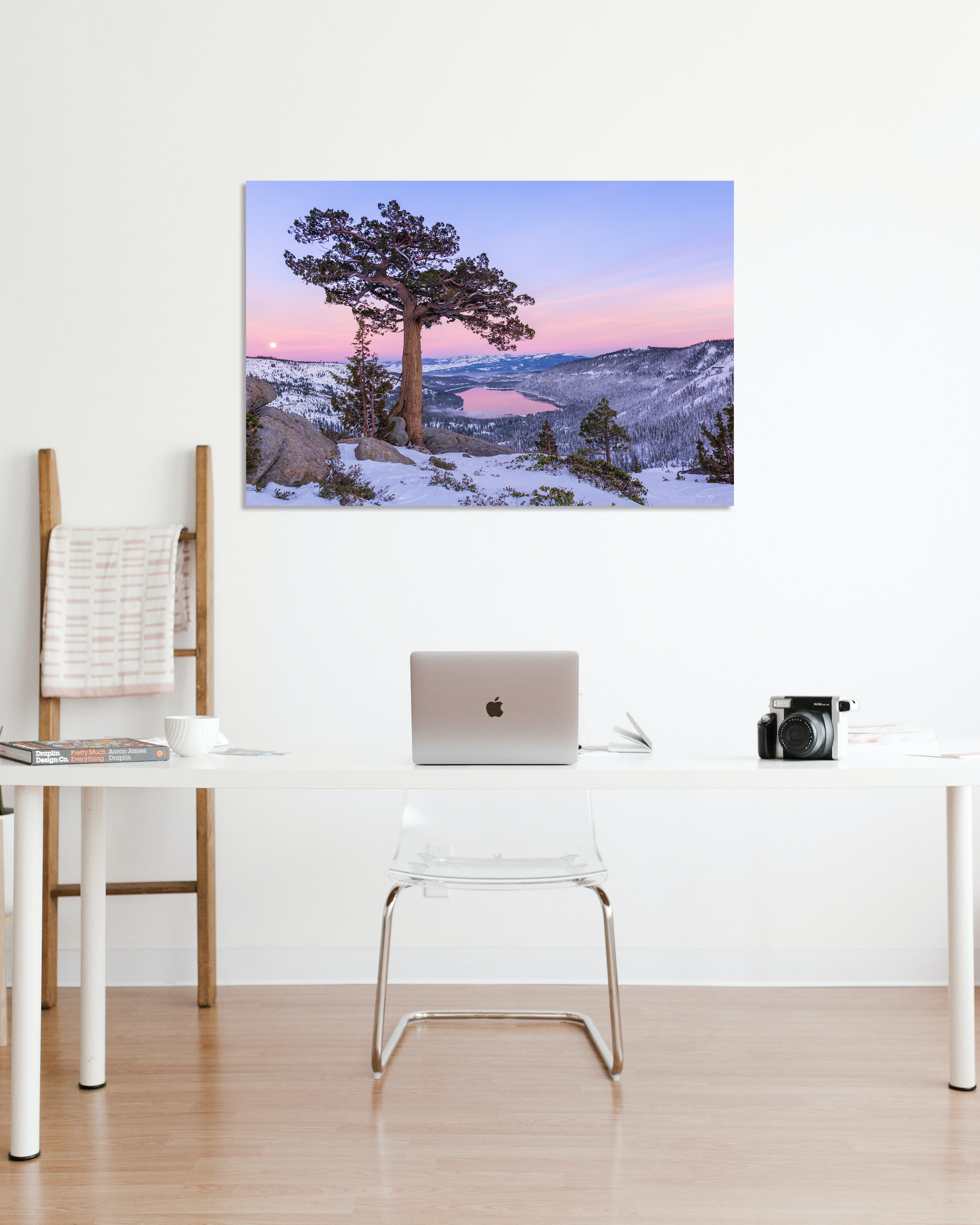 A photograph of a lone tree above Donner Lake at sunset hangs above a small desk.