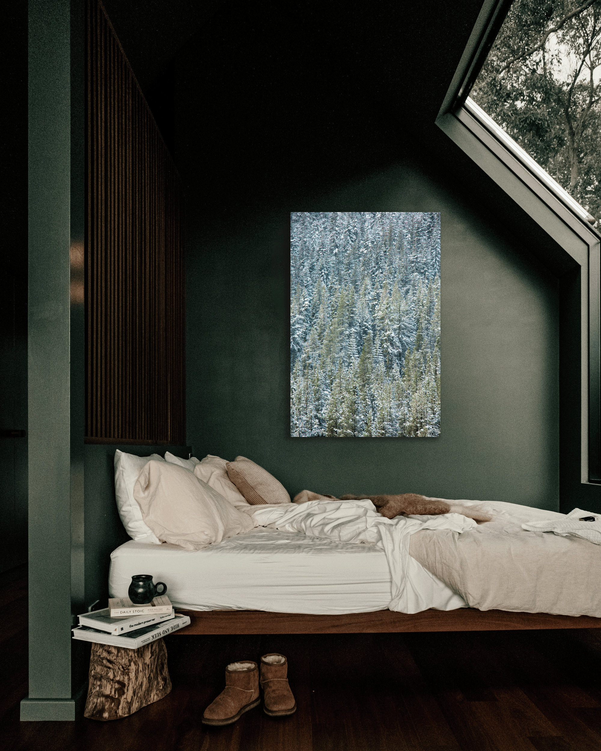 A green bedroom wall is decorated with a photograph of snow-loaded pine trees.