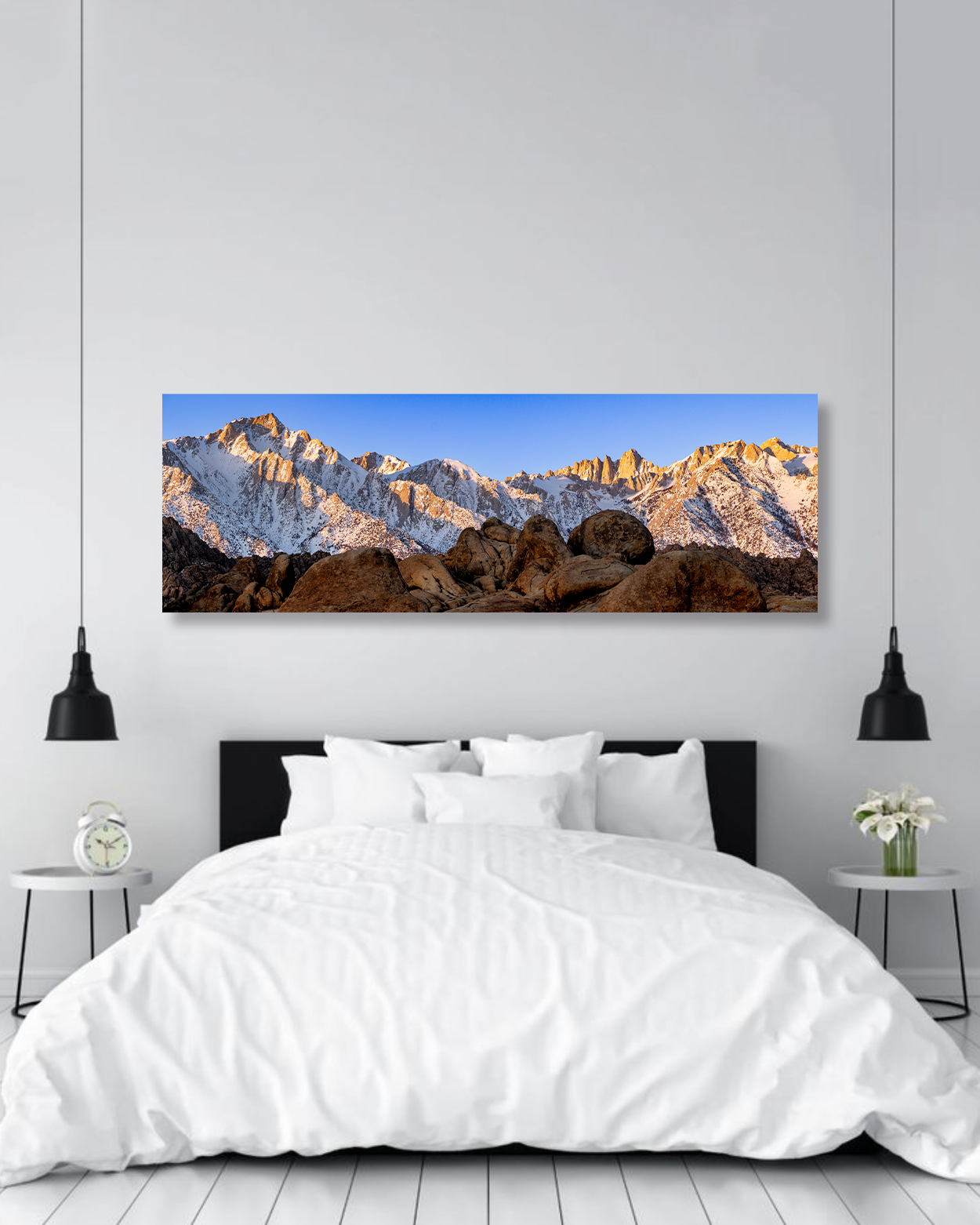A large photograph of the Alabama Hills in the sunrise hangs above a king sized bed.