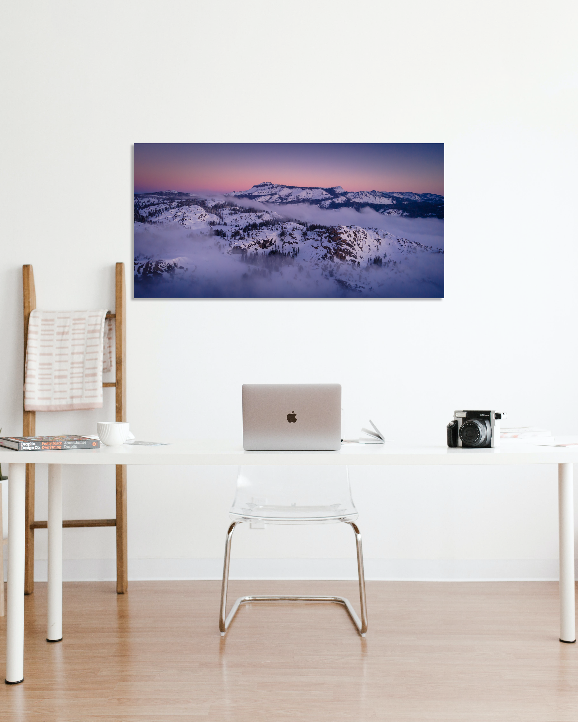 An office is decorated with a snowy mountain sunset image on the wall.