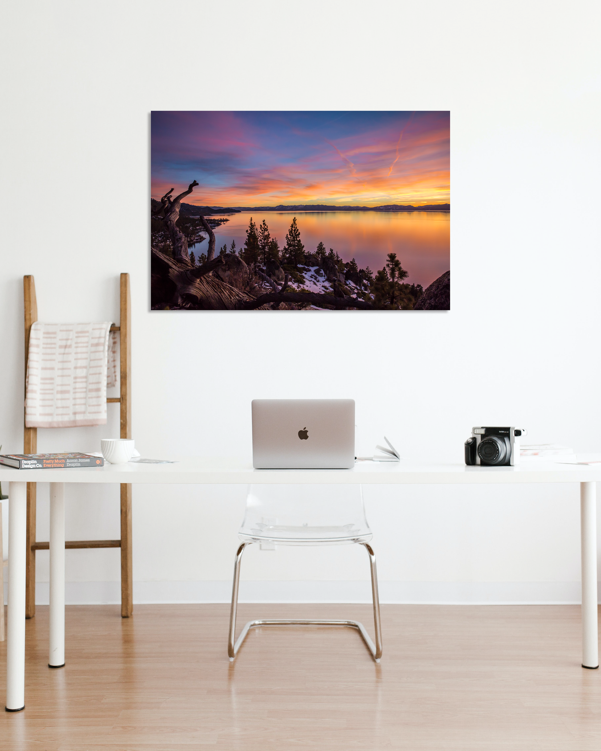 A single chair desk is complemented by a stunning sunset photo on the all.