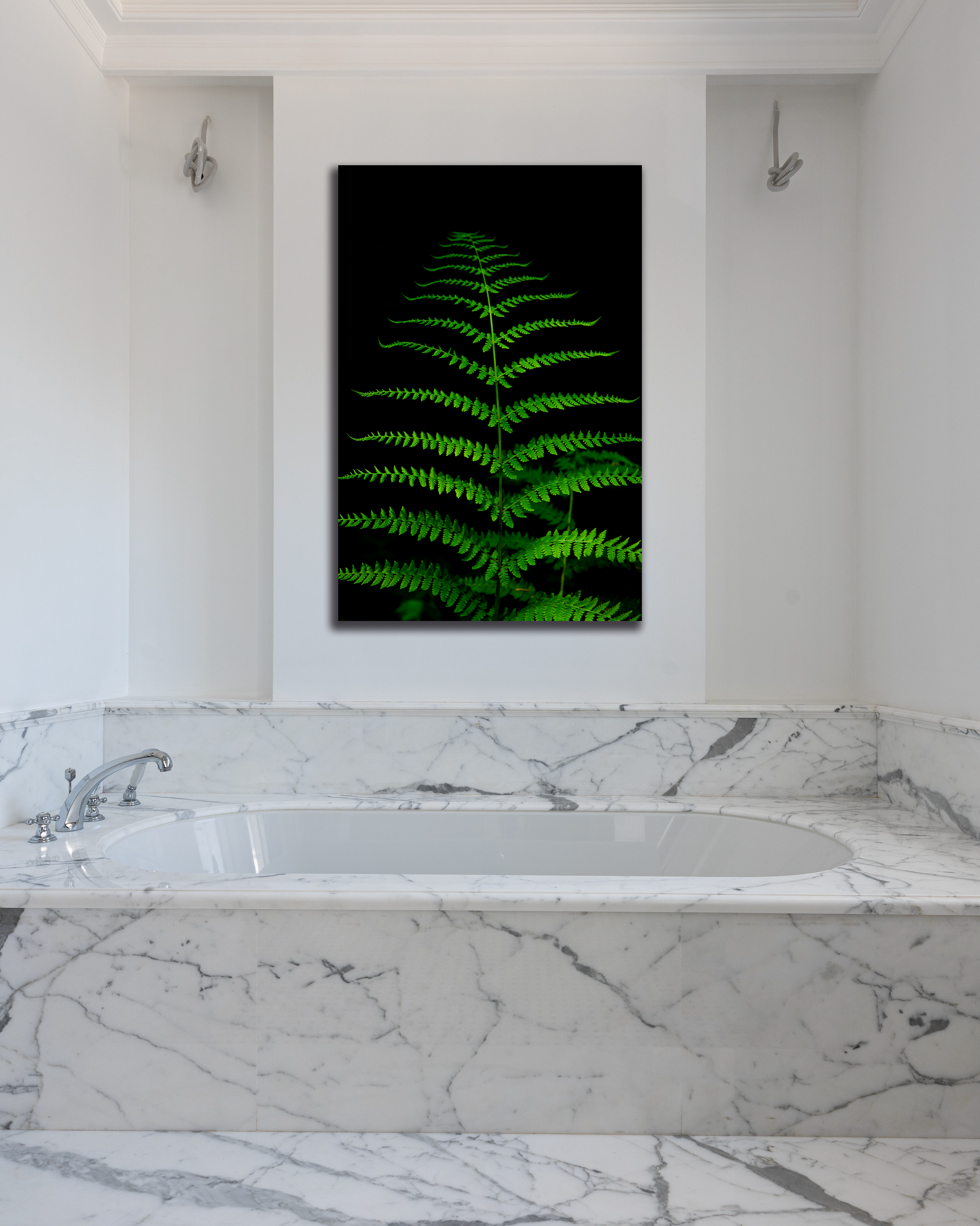 An upscale bathroom showcases a bright green image of a singular fern.