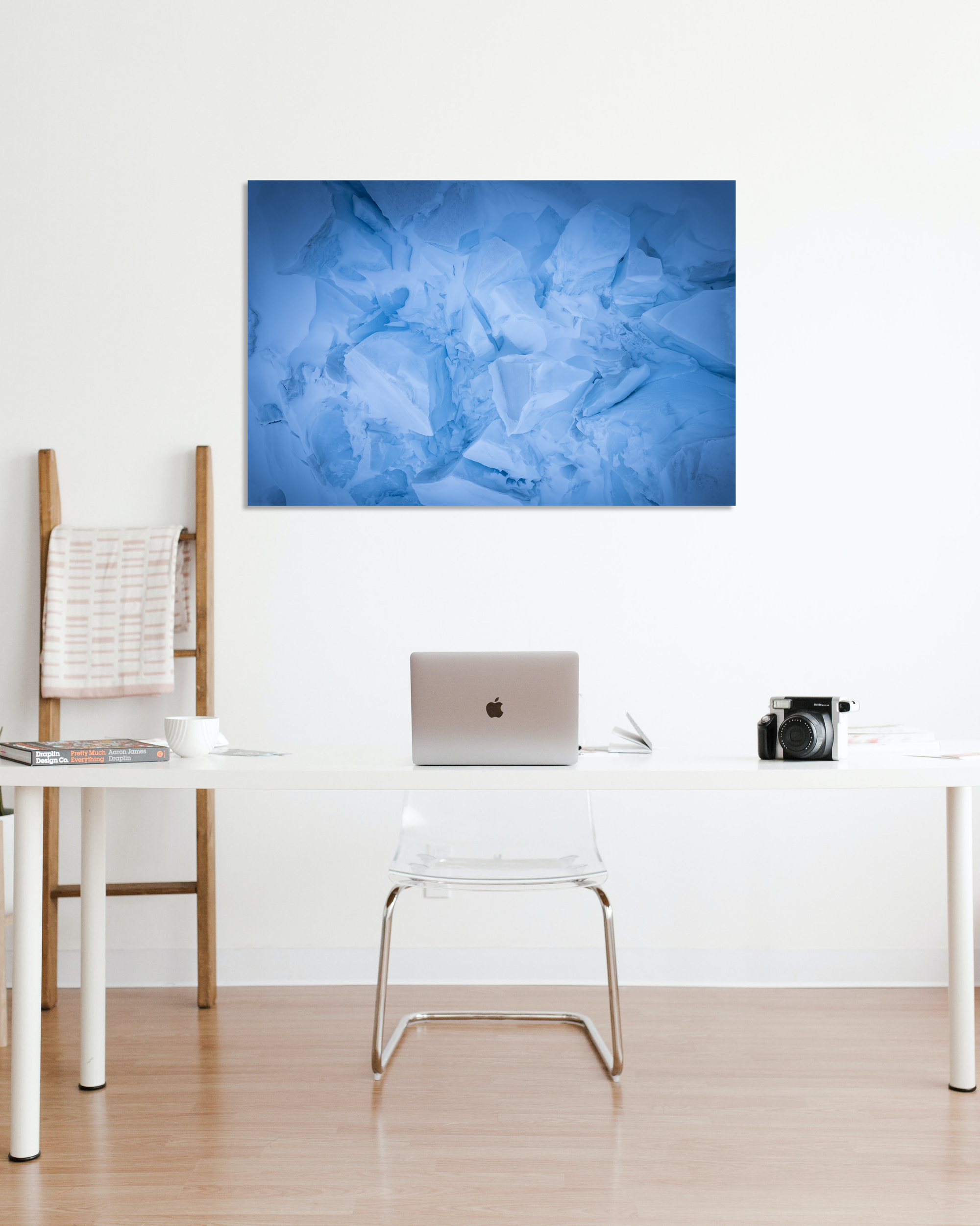 A small office showcases a photograph on the wall of glacial blocks of snow.