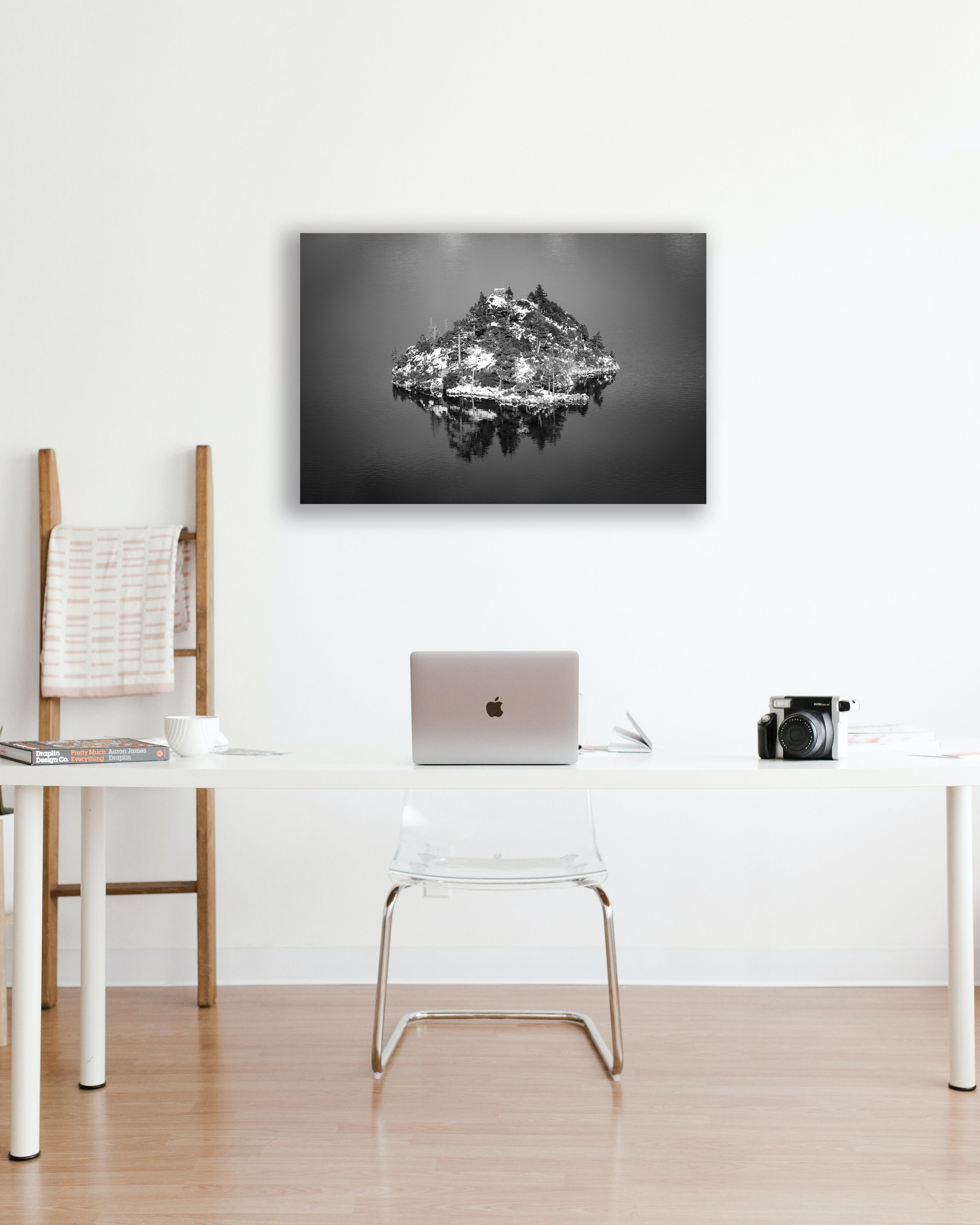 A black and white photograph hangs above an office desk.