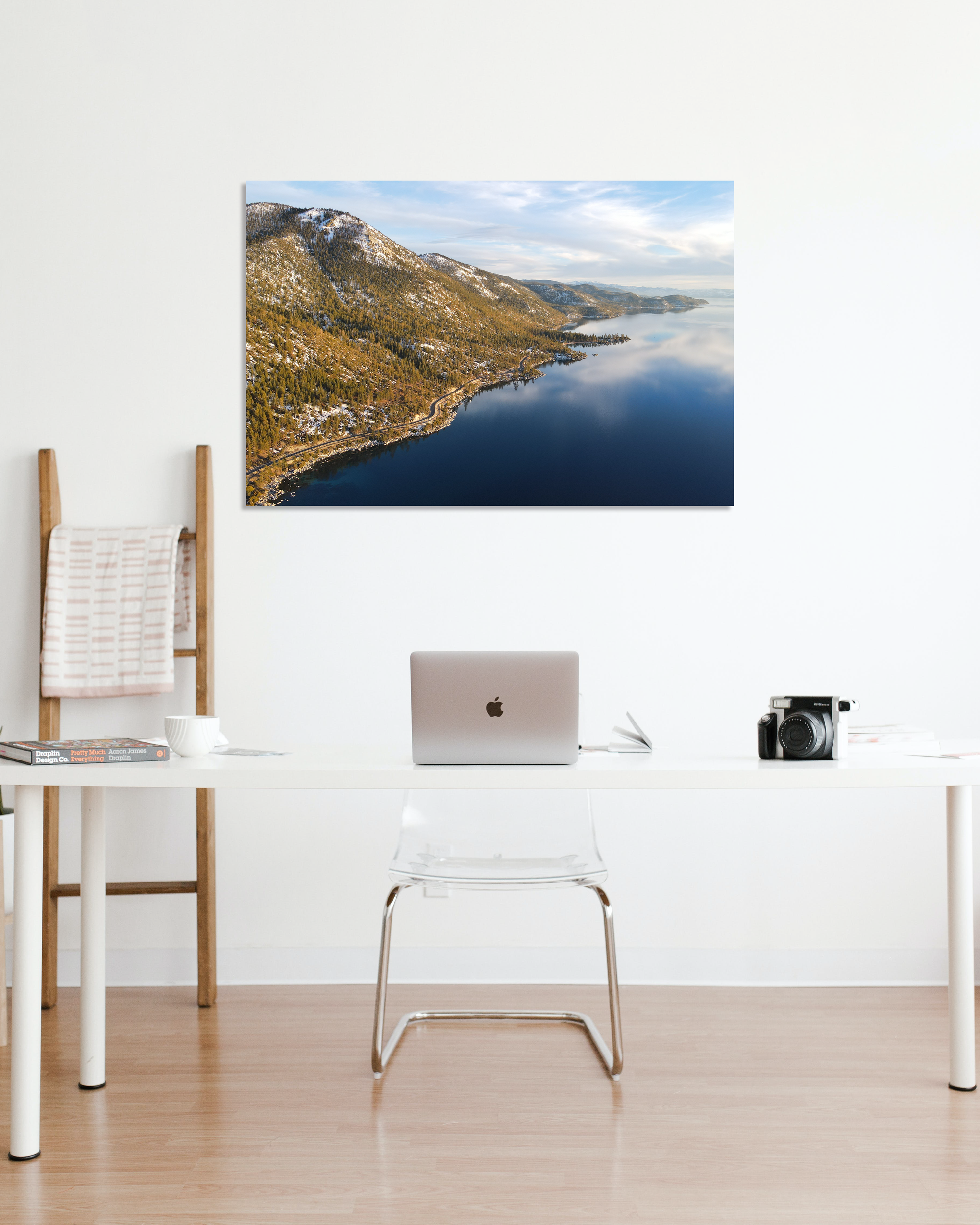 A mountain and water landscape image adorns the walls of a small office.