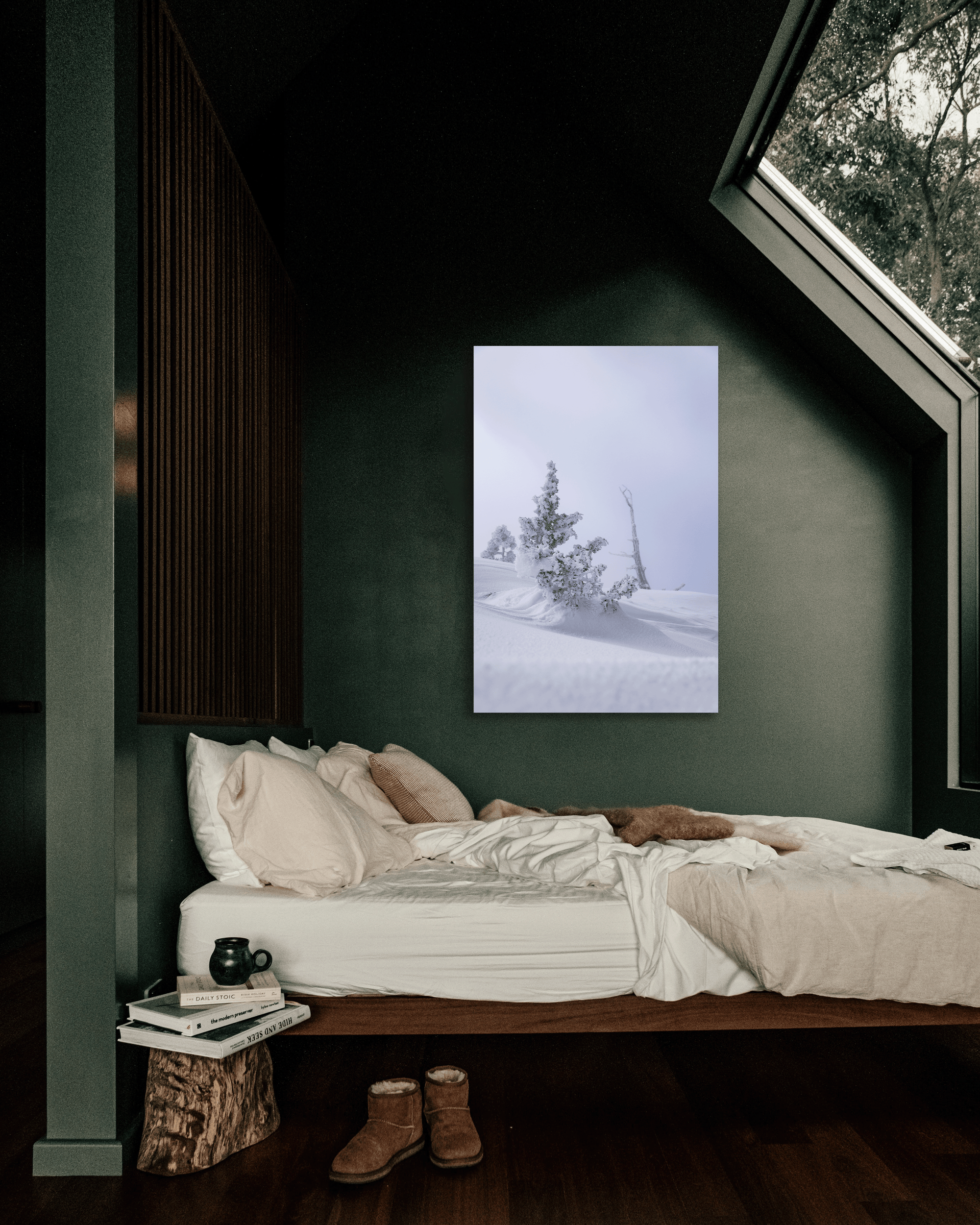 A bedroom wall showcases a photograph showing snow-laden windswept pine trees.