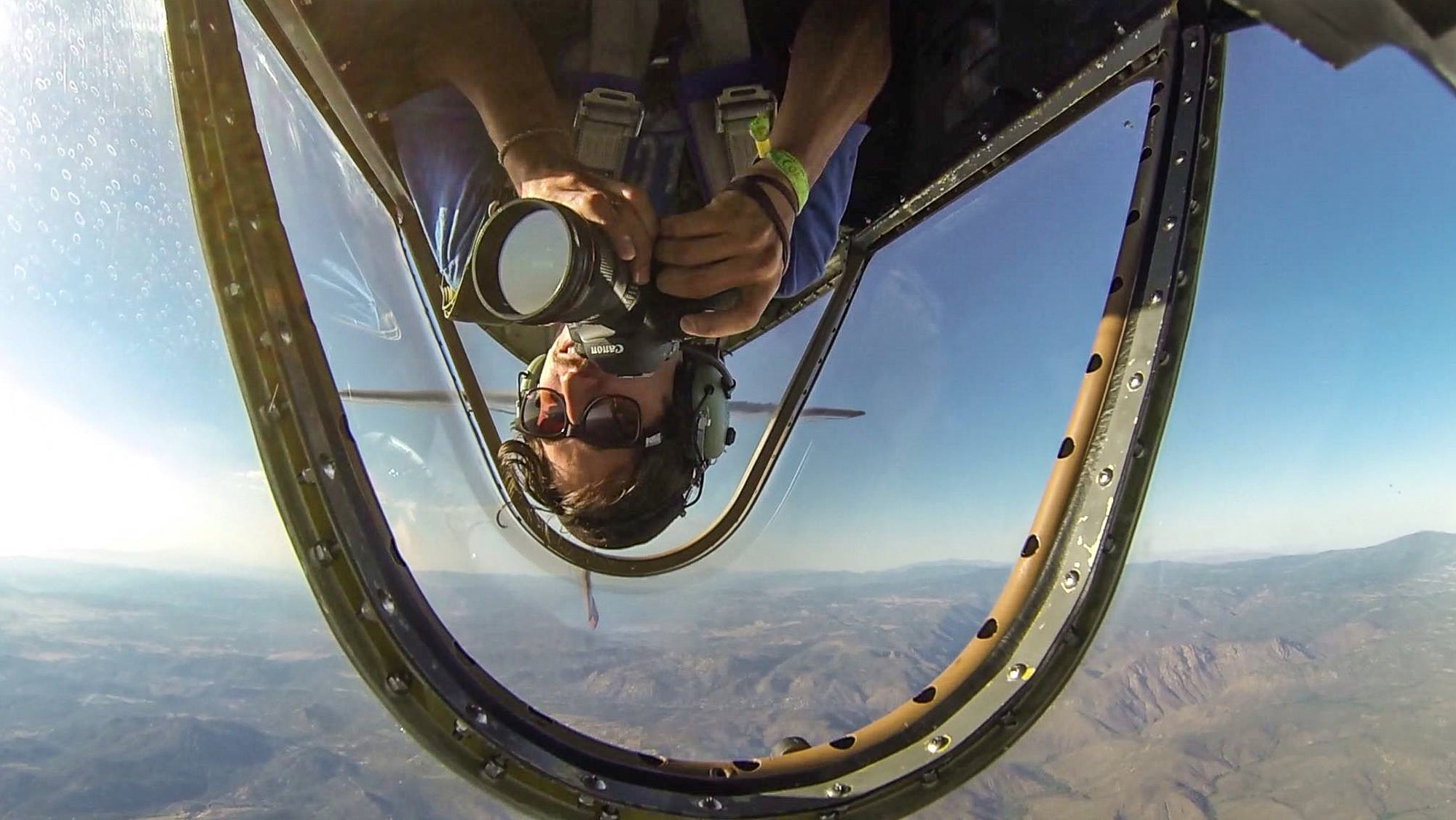 A photographer goes inverted in an airplane high above the Nevada desert.