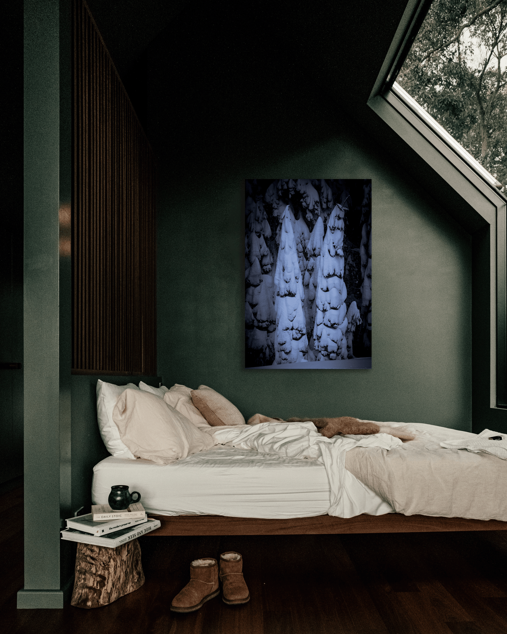 A photo of pine trees heavy with fresh snow hangs on a bedroom wall.