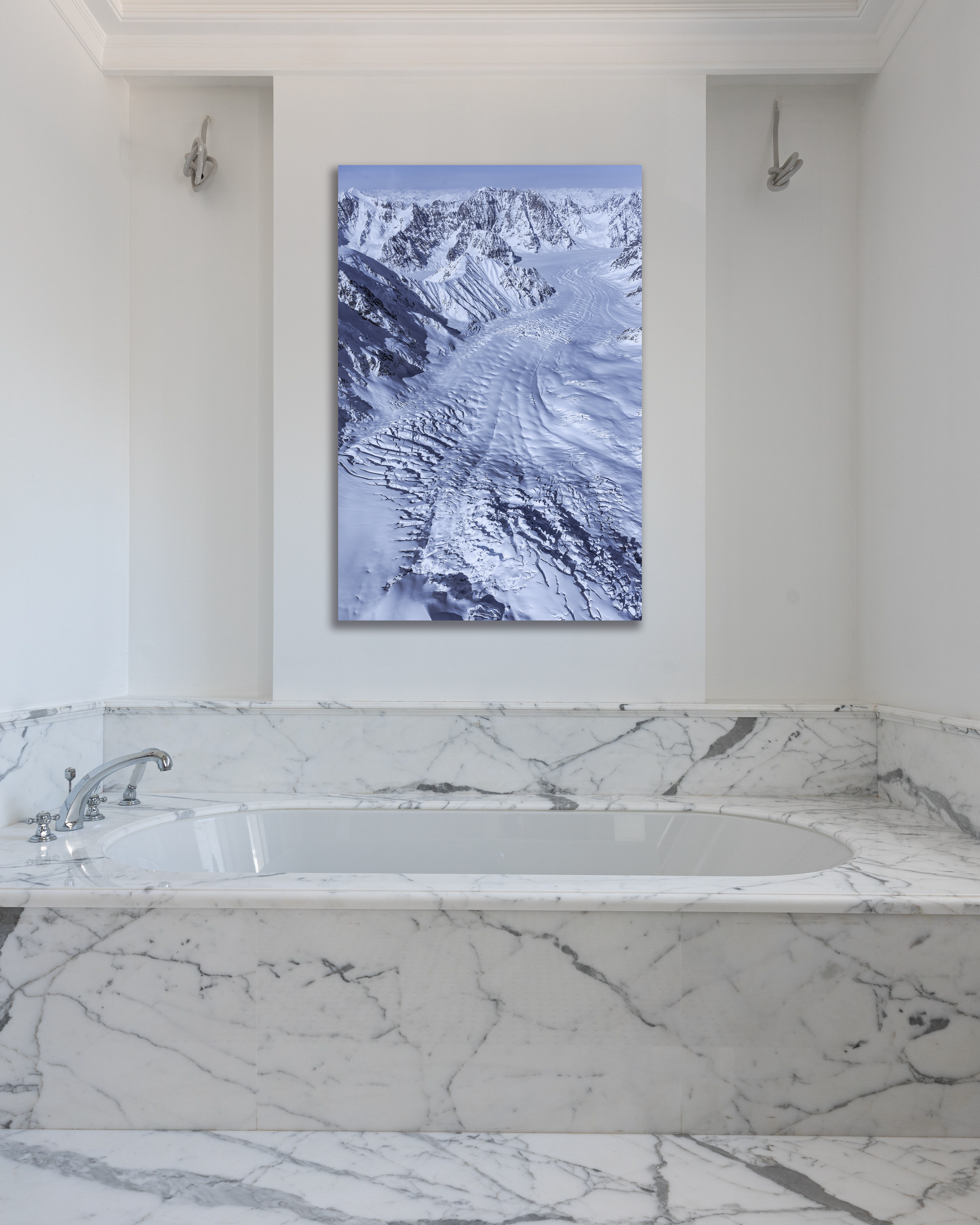 The slow creep of a glacier is depicted in a fine arts photograph that hangs above a marbled tub.