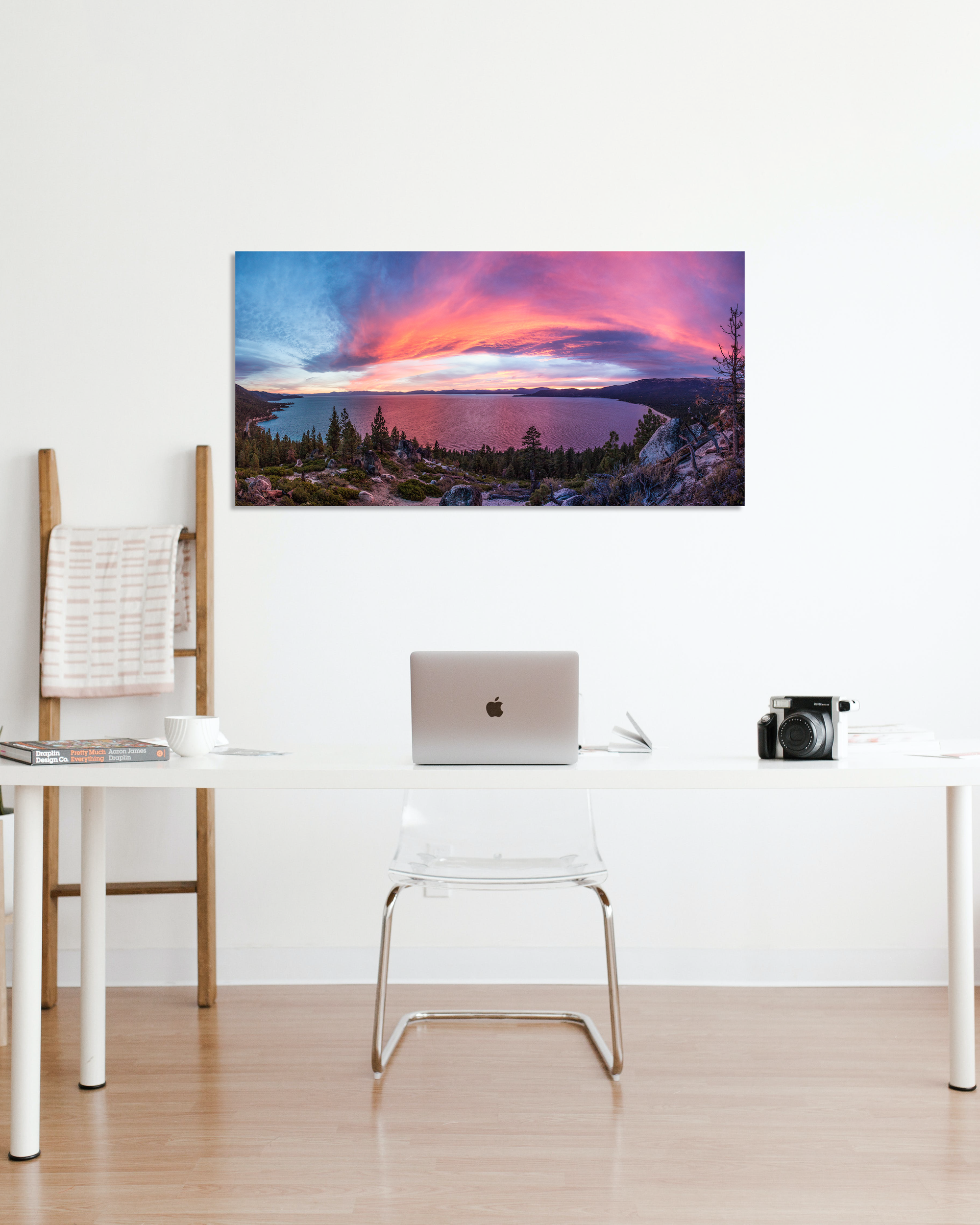 A vibrant pink sunset over Lake Tahoe decorates the wall of a small office.