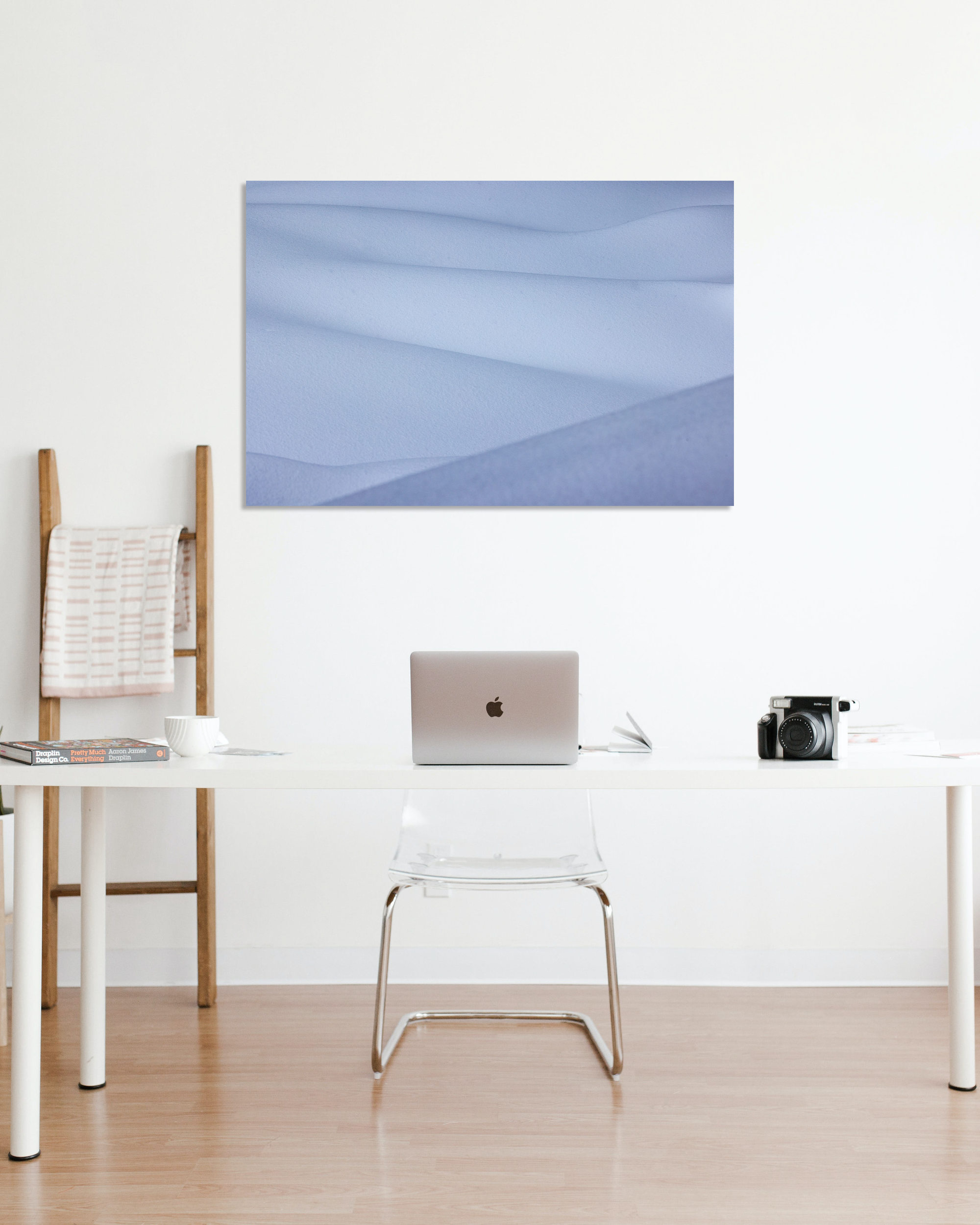 A small office is decorated with a photo depicting snow drifts.