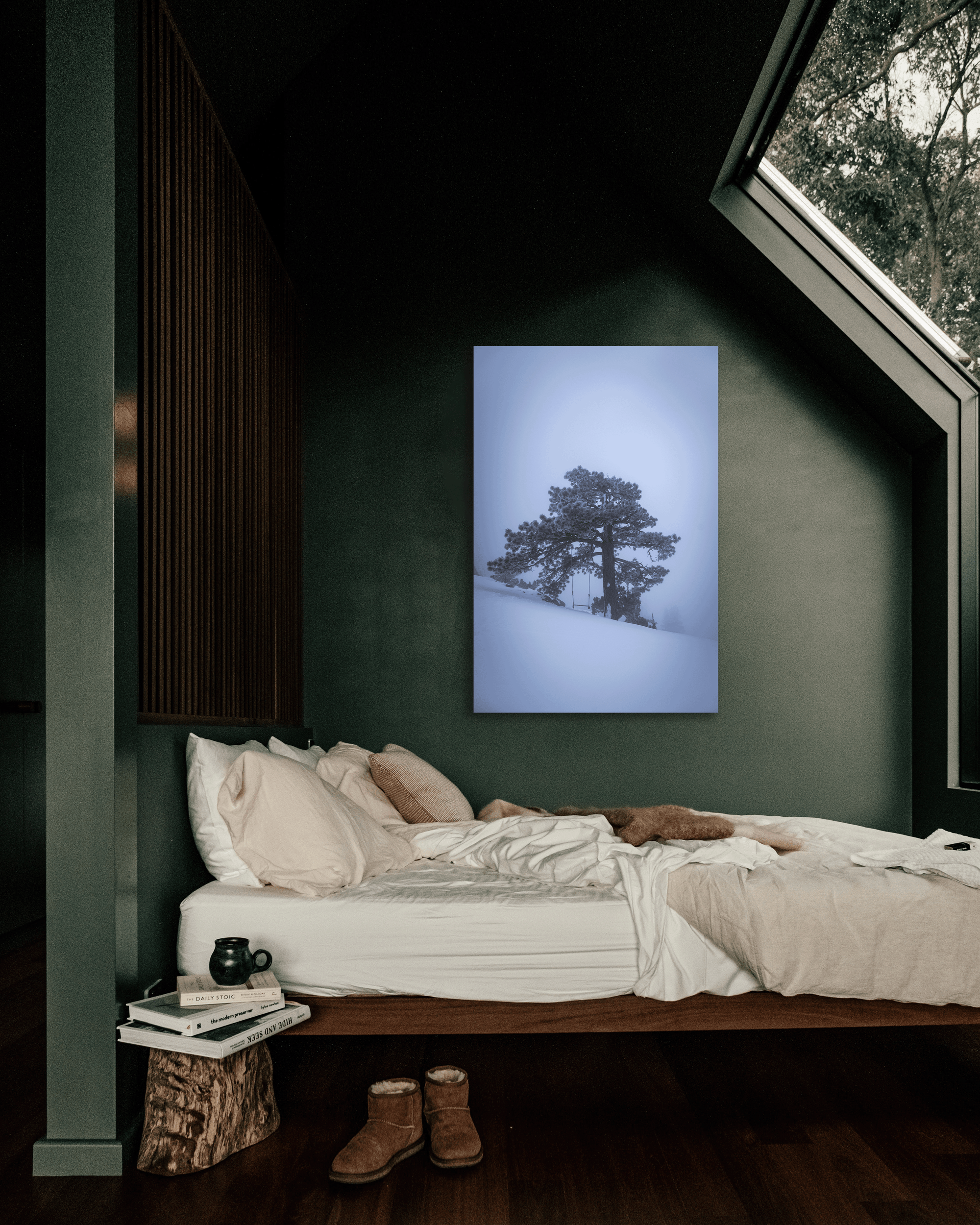 A photograph depicting a lone tree shrouded in winter weather hangs on a bedroom wall.