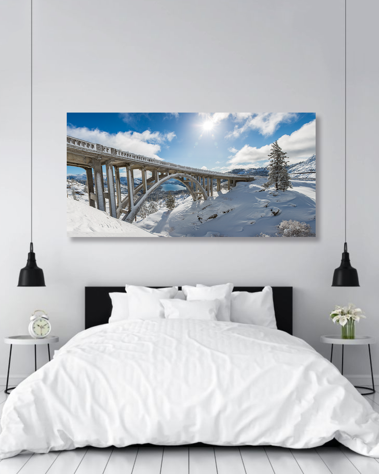 A photo of an arched bridge surrounded by snow hangs on a bedroom wall.