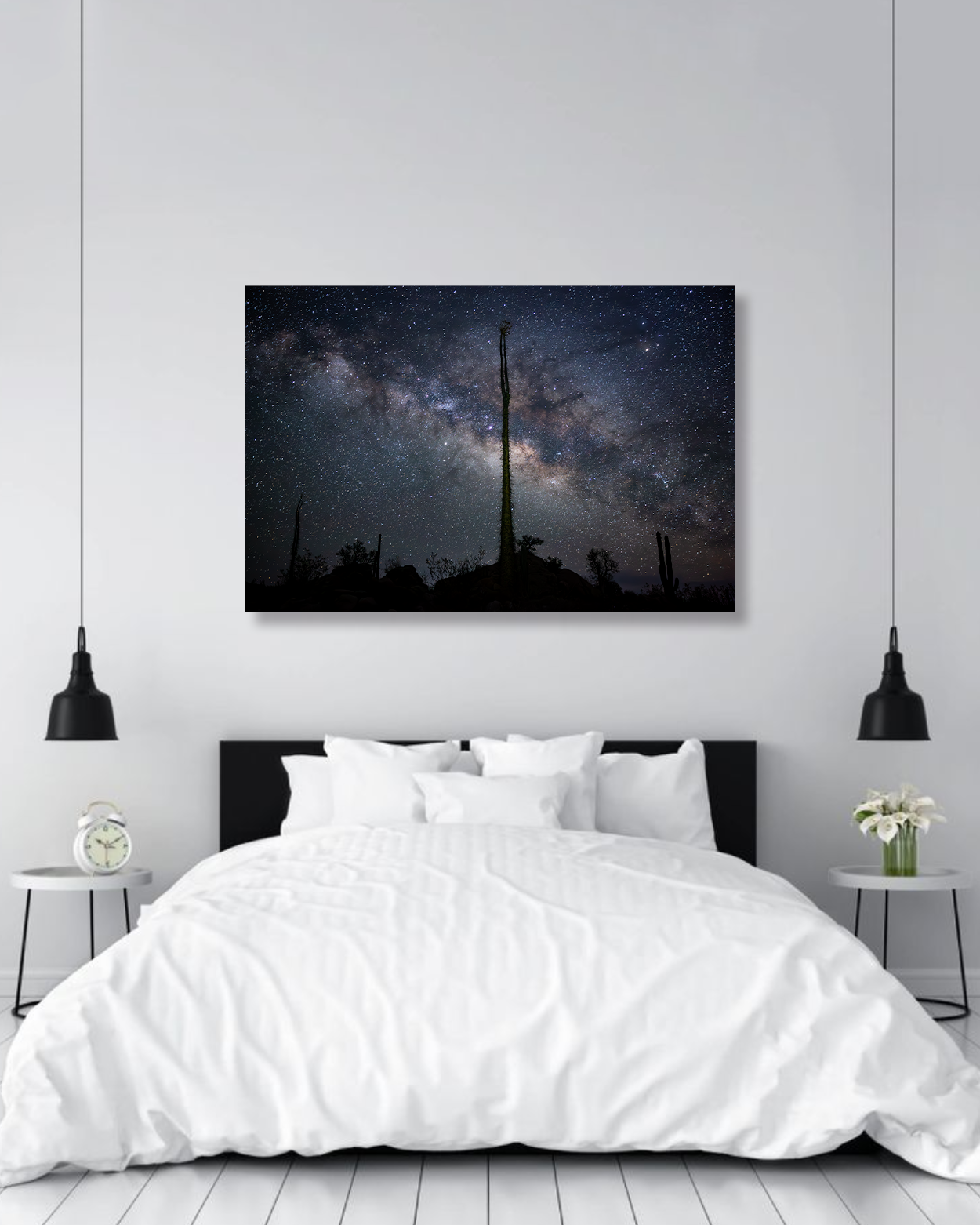 A large photograph of the milky way hangs on a bedroom wall.