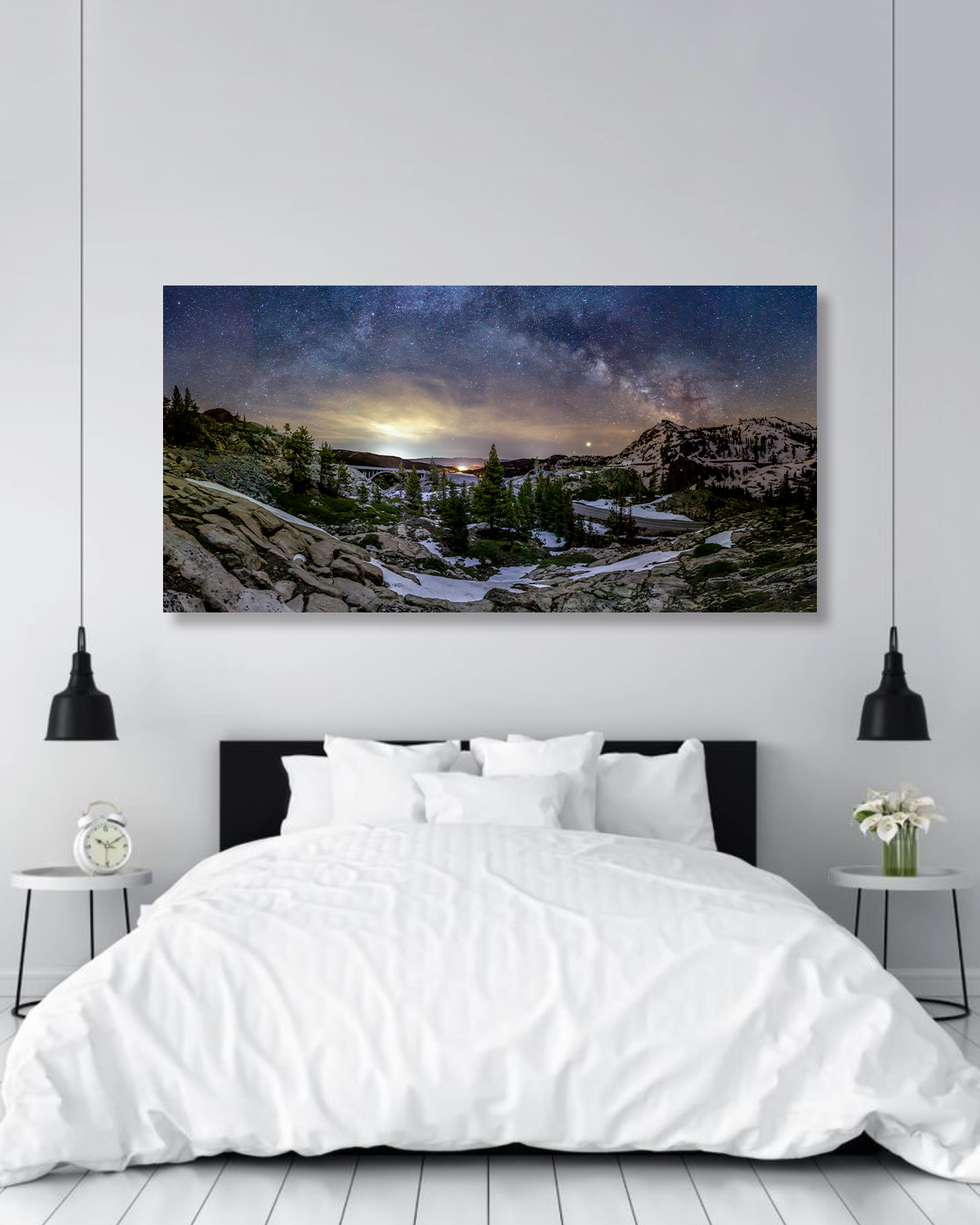 A modern bedroom showcases a large fine art photography print of the Milky Way above the bed.