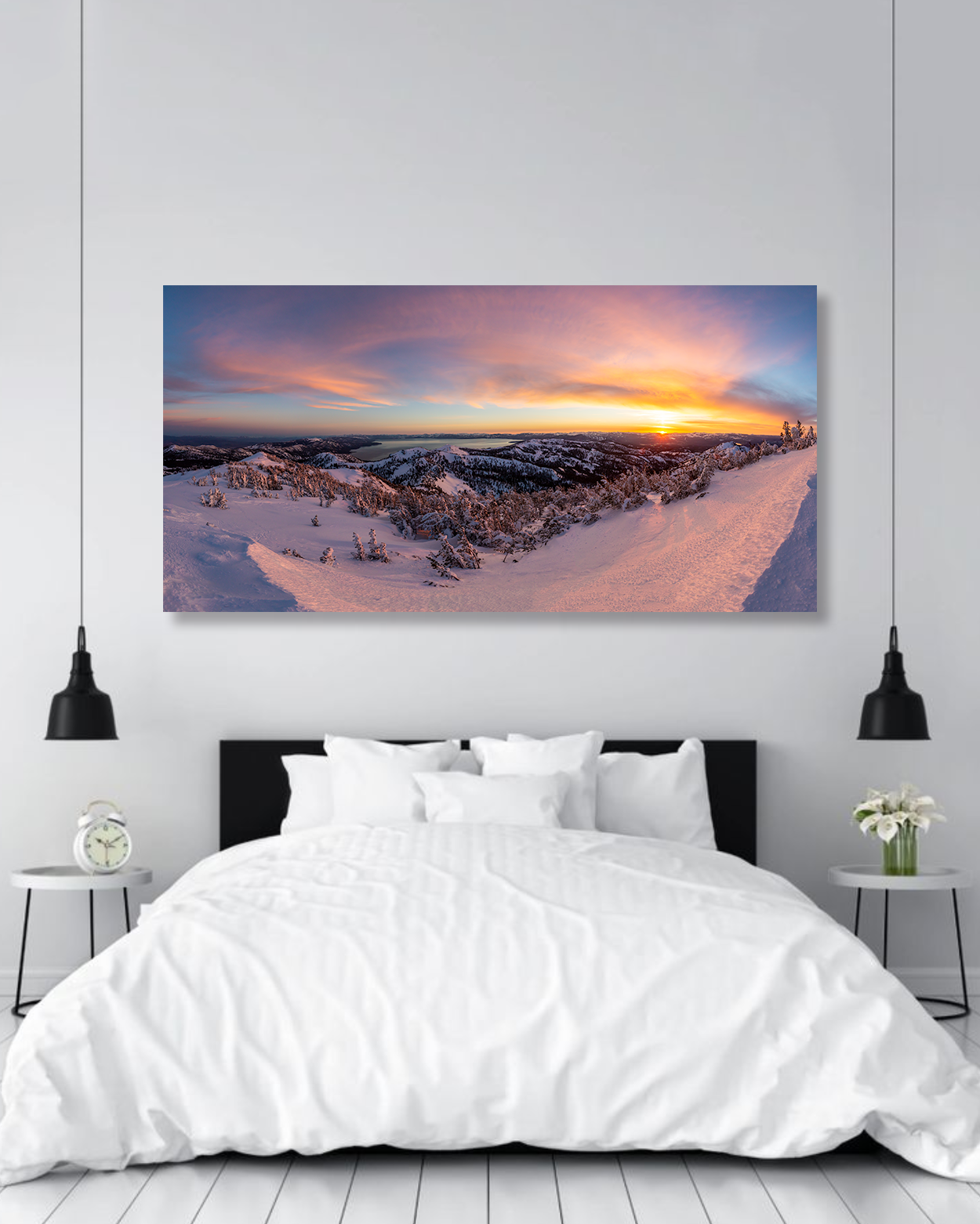 A photo of a sunset above a lake hanging on the wall of a bedroom.