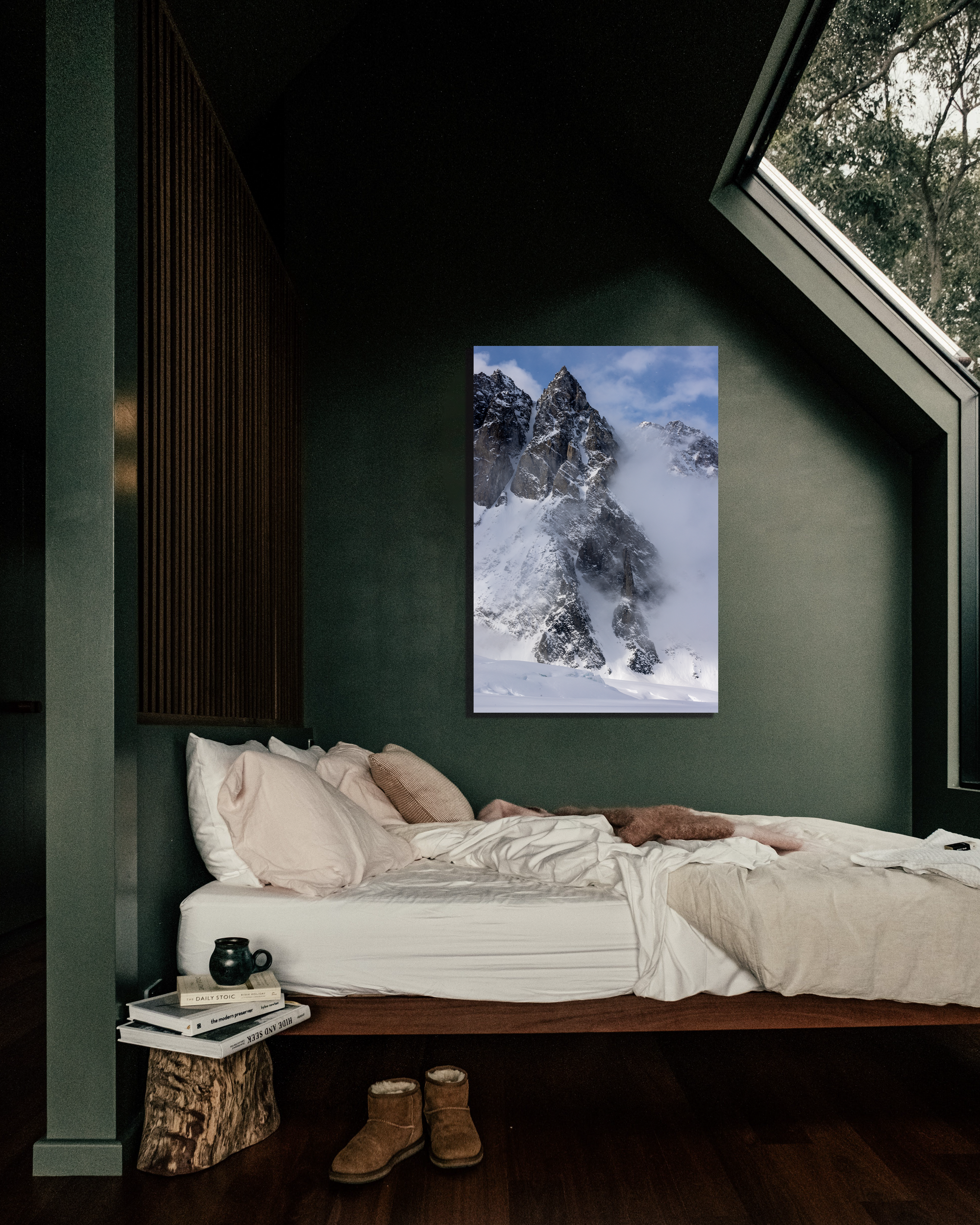 A cozy room with a fine art print of mountains on the wall.