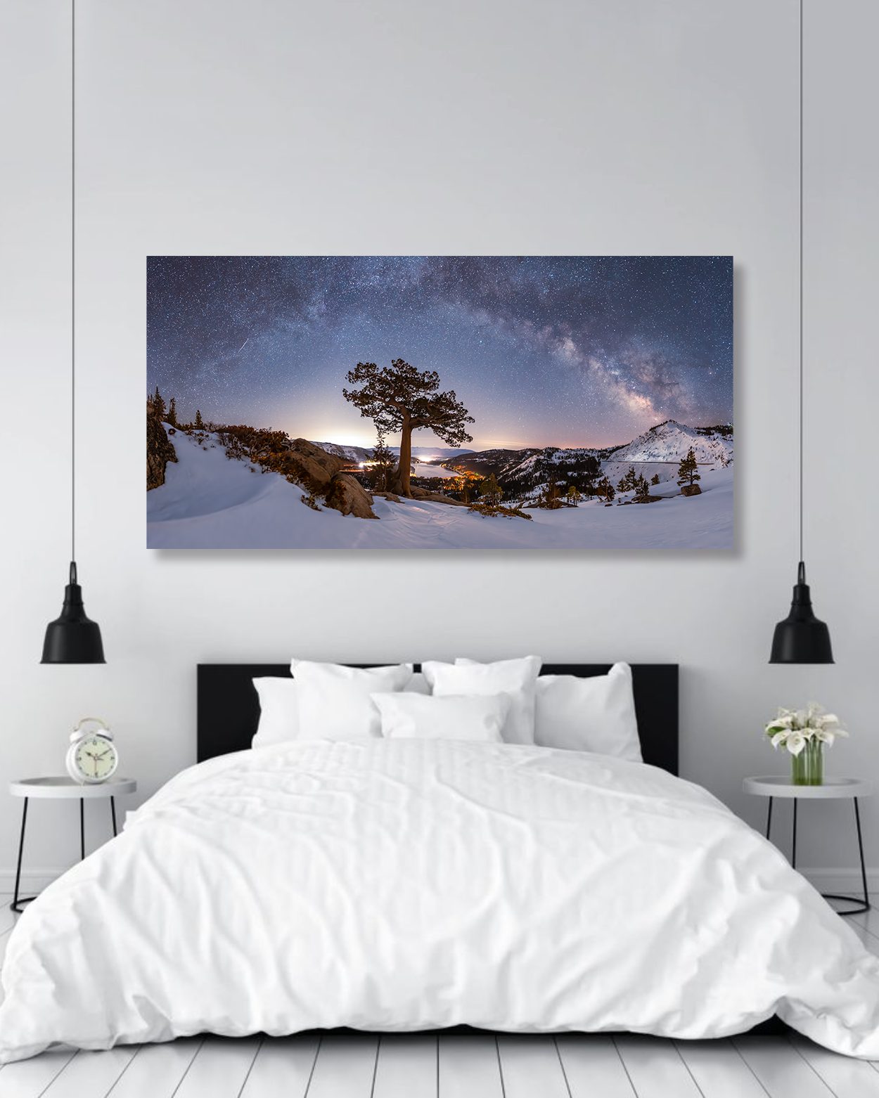 A master bedroom wall is decorated of a photograph showcasing the Milky Way over snowy mountains and Donner Lake.