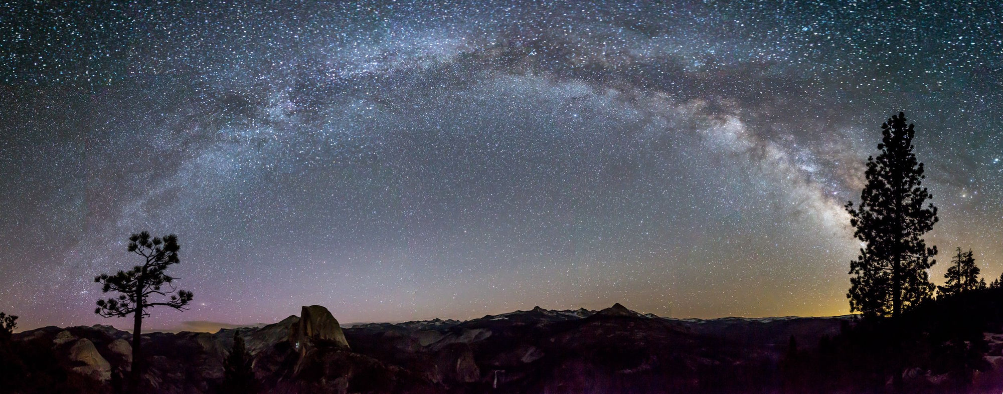 The Milky Way arches over Half Dome in Yosemite National Park.